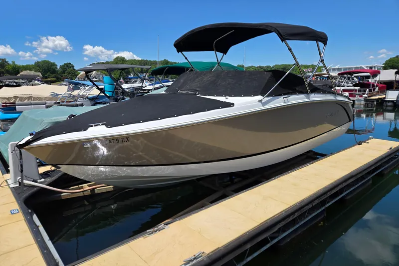 The Image of 2016 Cobalt R3 boat docked with black cover and canopy, surrounded by other boats. - 1