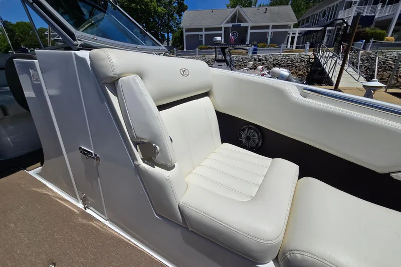 Slide: The Image of 2016 Cobalt R3 boat interior with white leather seating and speaker, dockside view. - 12
