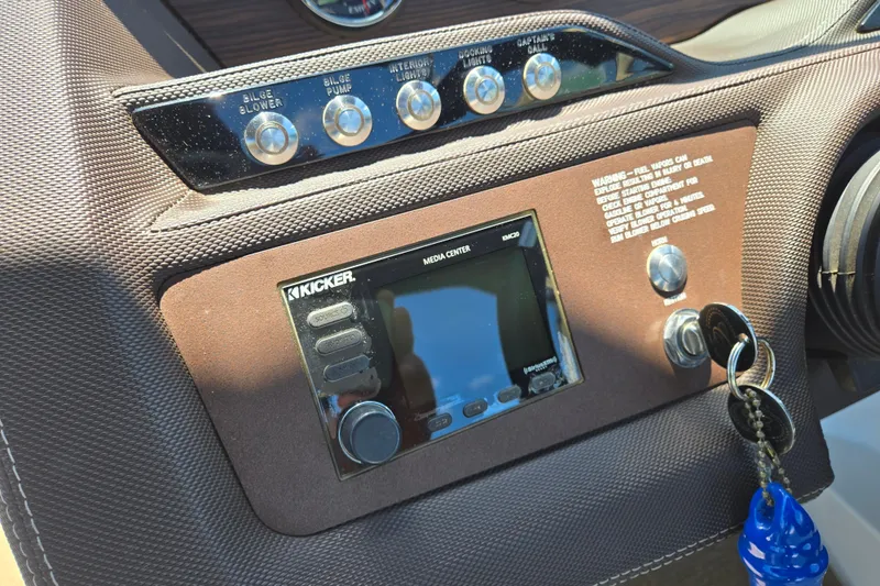 Slide: The Image of Dashboard of a 2016 Cobalt R3 boat featuring a Kicker media center and control switches. - 23