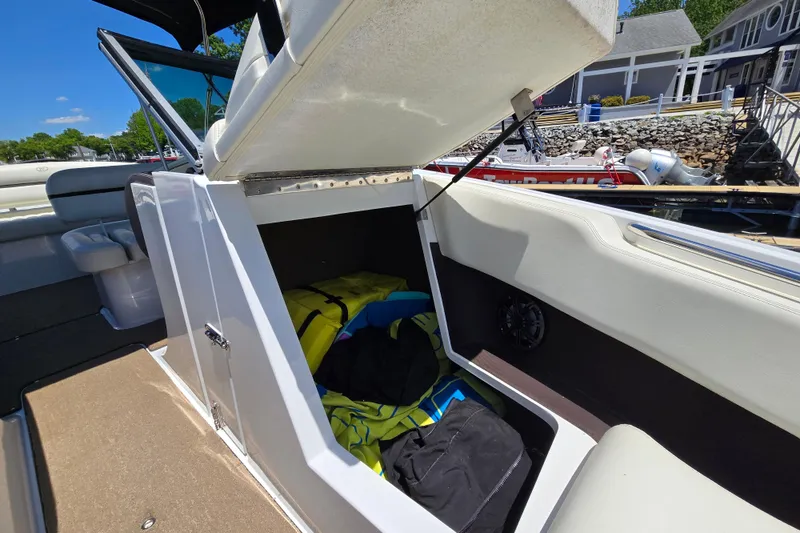 Slide: The Image of Open storage compartment on a 2016 Cobalt R3 boat, revealing life jackets and gear. - 32