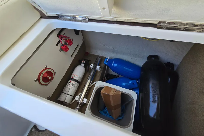 Slide: The Image of Storage compartment in a 2016 Cobalt R3 boat with safety equipment and fenders. - 34