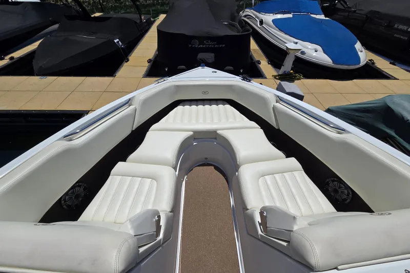 Slide: The Image of 2016 Cobalt R3 boat interior with white seating, docked alongside covered boats. - 9