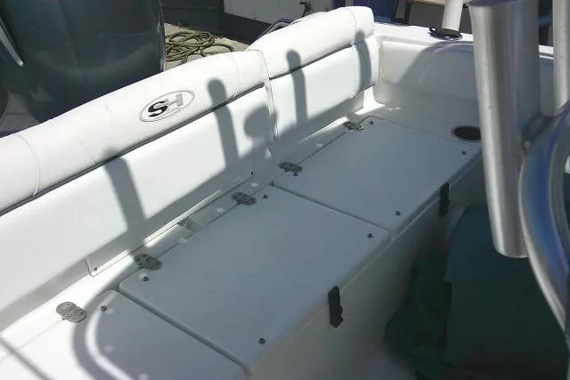 Slide: The Image of 2017 Sea Hunt Ultra 211 boat interior with white seating and storage compartments. - 25