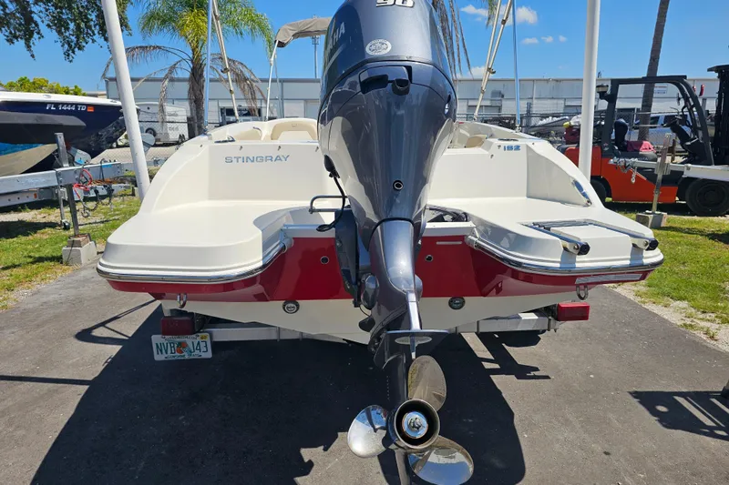 Slide: The Image of 2019 Stingray 182 SC boat with Yamaha outboard motor, parked outdoors. - 11