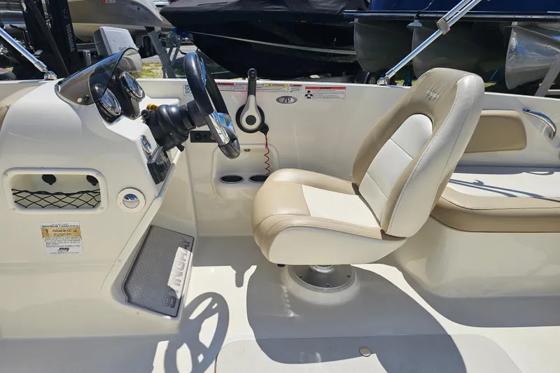 Slide: The Image of 2019 Stingray 182 SC boat cockpit with steering wheel and beige seating. - 15