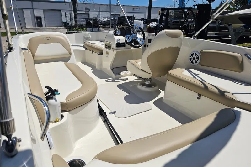 Slide: The Image of 2019 Stingray 182 SC boat interior with beige seating and steering console. - 16