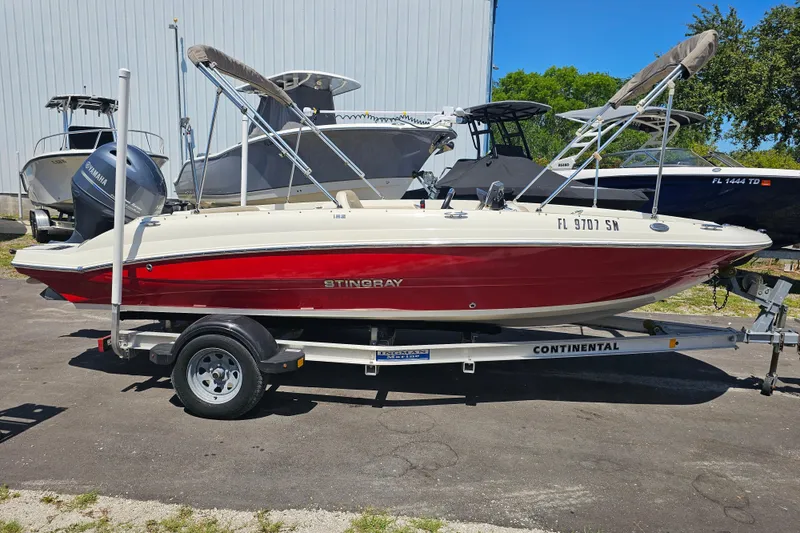 Slide: The Image of 2019 Stingray 182 SC boat on trailer, red and white design, parked outdoors. - 3
