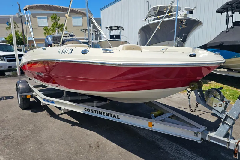 Slide: The Image of 2019 Stingray 182 SC boat on trailer, red and white design, parked outdoors. - 4