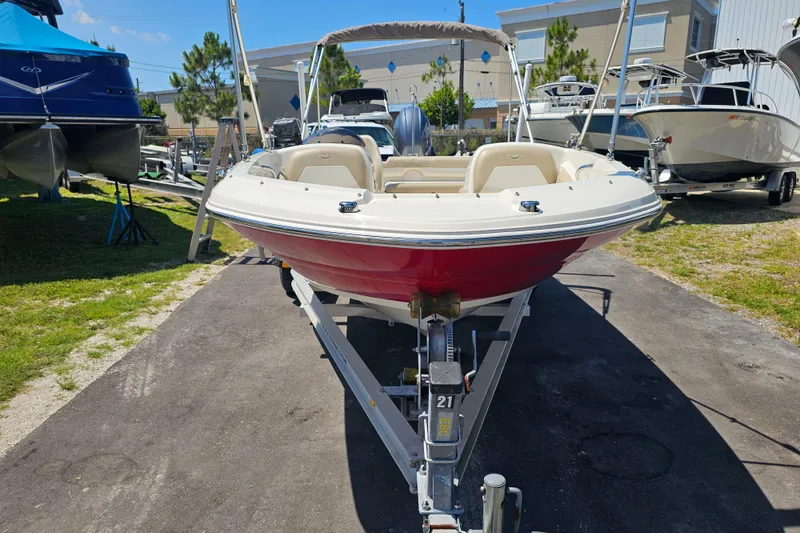 Slide: The Image of 2019 Stingray 182 SC boat on trailer, red hull, parked outdoors. - 6