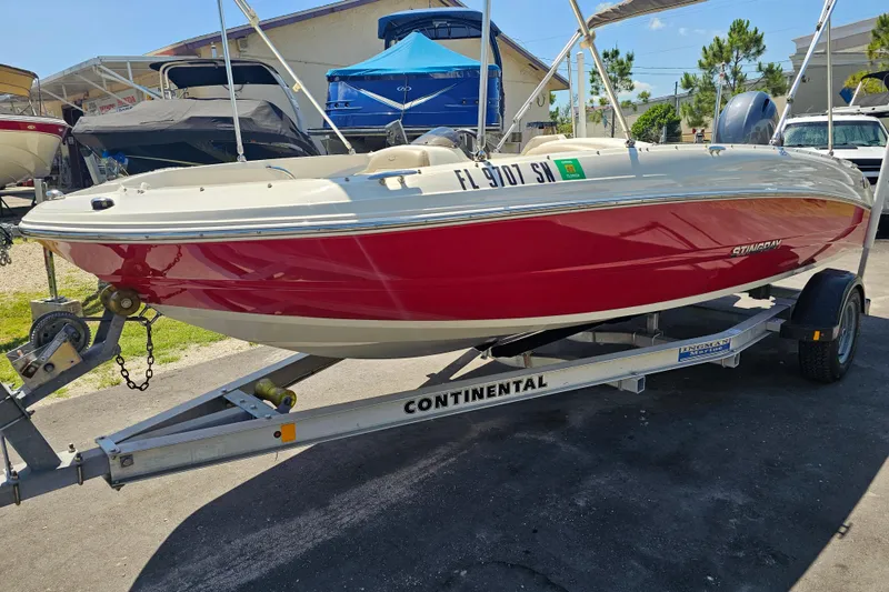 Slide: The Image of 2019 Stingray 182 SC boat on trailer, red and white design, parked outdoors. - 7