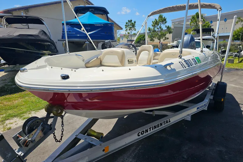 Slide: The Image of 2019 Stingray 182 SC boat on trailer, red and white, parked outdoors. - 8