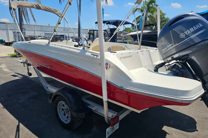 Slide: The Image of 2019 Stingray 182 SC boat with Yamaha engine, red and white design, parked outdoors. - 9