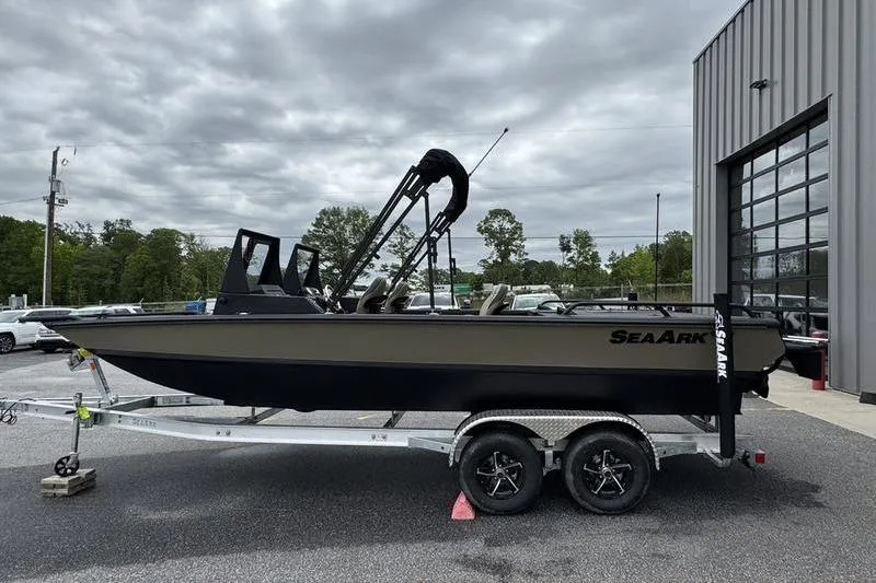 Slide: The Image of 2026 SeaArk Predator 300 AK boat on trailer, parked outdoors near a building. - 16