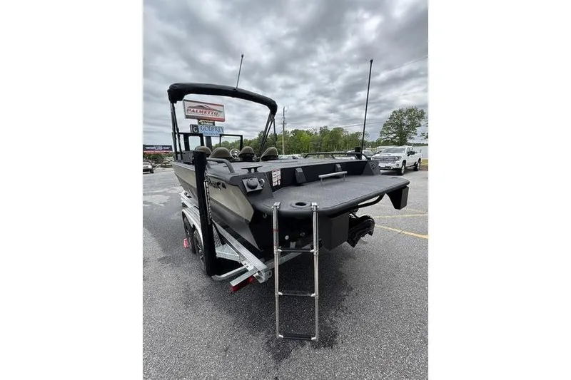 Slide: The Image of 2026 SeaArk Predator 300 AK boat with ladder, parked outdoors under cloudy skies. - 17