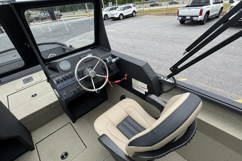 Slide: The Image of Interior of 2026 SeaArk Predator 300 AK boat, featuring steering wheel and captain's chair. - 19