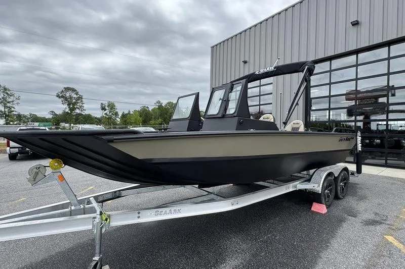 Slide: The Image of 2026 SeaArk Predator 300 AK boat on trailer outside a modern building. - 20