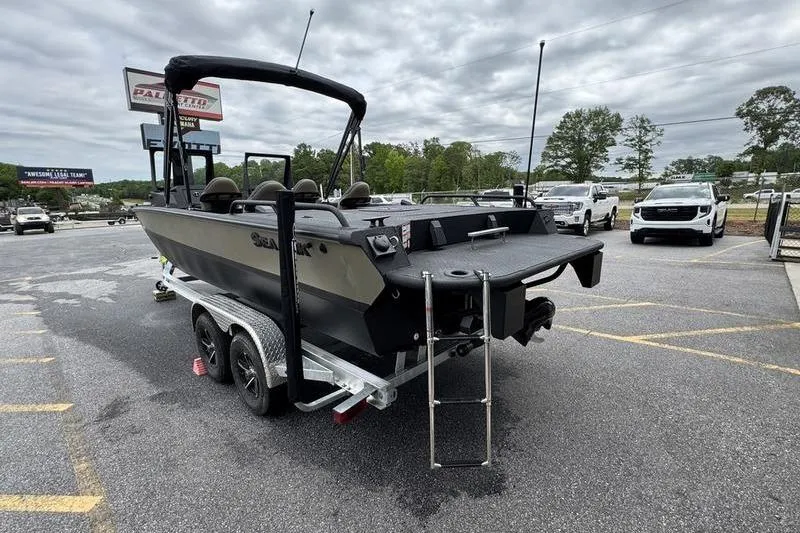Slide: The Image of 2026 SeaArk Predator 300 AK boat on trailer in parking lot, overcast sky. - 3