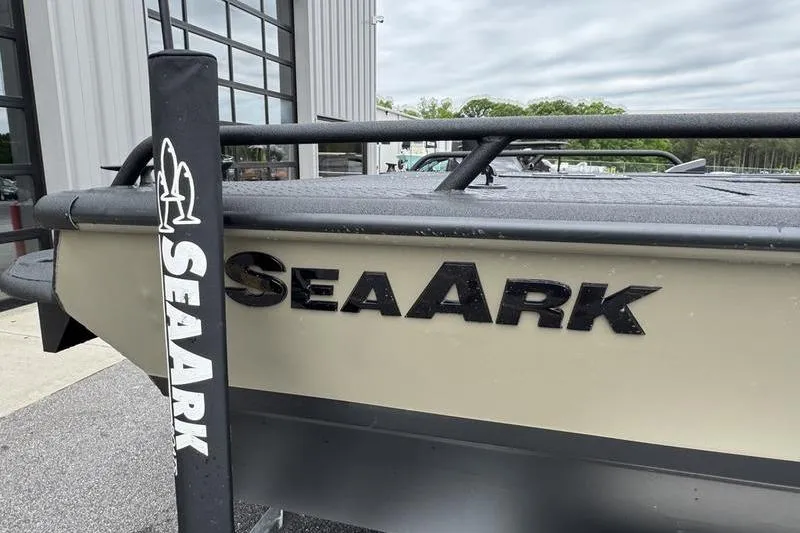 Slide: The Image of 2026 SeaArk Predator 300 AK boat exterior with logo, parked near a building. - 5