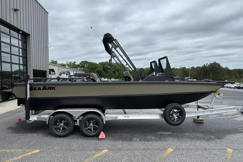 Slide: The Image of 2026 SeaArk Predator 300 AK boat on trailer, parked outdoors near a building. - 7