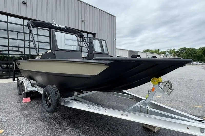 Slide: The Image of 2026 SeaArk Predator 300 AK boat on trailer, parked outside a modern building. - 8