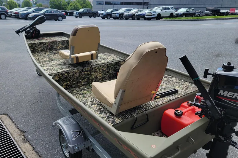 Slide: The Image of 2025 Tracker Grizzly 12 Jon boat with camo seats and Mercury outboard motor. - 5