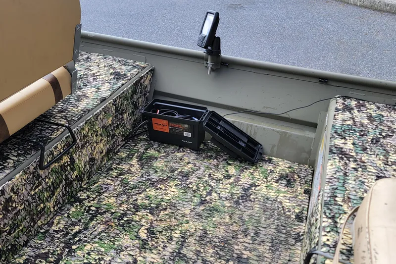 Slide: The Image of Interior of 2025 Tracker Grizzly 12 Jon boat with camo seats and battery box. - 7