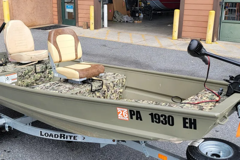 Slide: The Image of 2025 Tracker Grizzly 12 Jon boat on LoadRite trailer, featuring camouflage seating. - 8