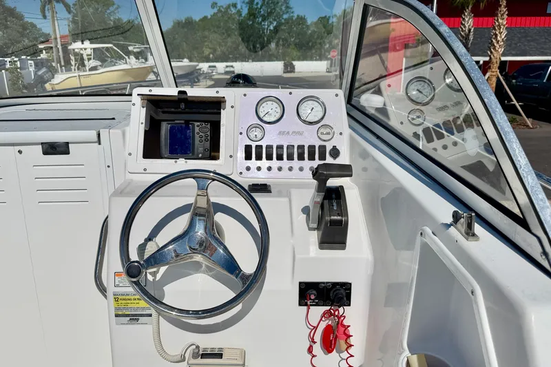 Slide: The Image of 2005 Sea Pro 220 Walk Around boat dashboard with steering wheel and control panel. - 19
