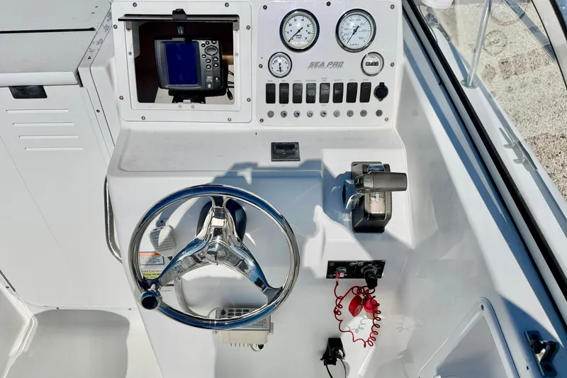 Slide: The Image of 2005 Sea Pro 220 Walk Around boat dashboard with steering wheel and gauges. - 20