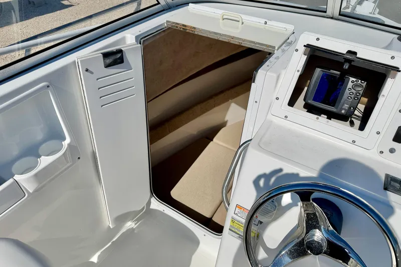 Slide: The Image of 2005 Sea Pro 220 Walk Around boat interior with steering wheel and navigation system. - 27