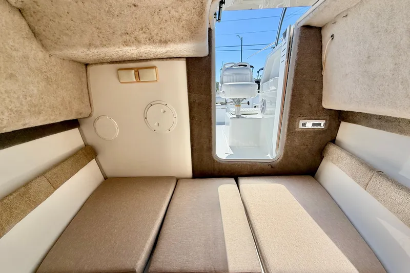 Slide: The Image of Interior cabin of 2005 Sea Pro 220 Walk Around boat, featuring cushioned seating and compact design. - 29