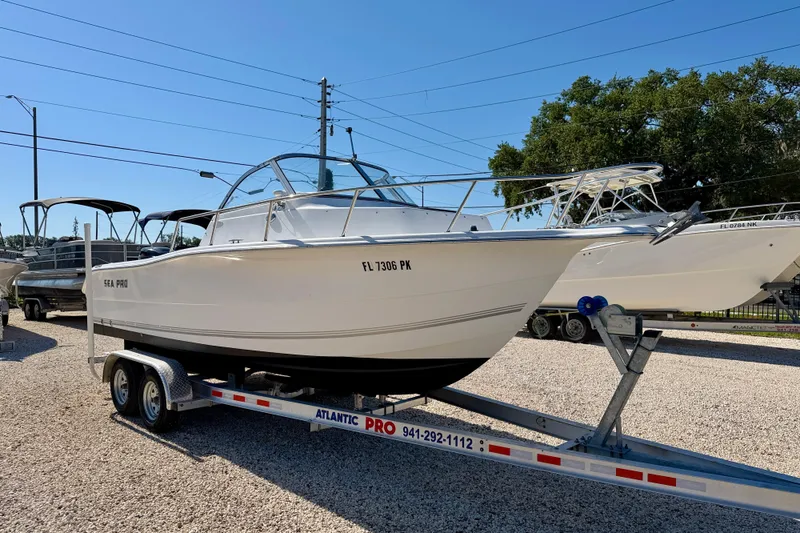 Slide: The Image of 2005 Sea Pro 220 Walk Around boat on trailer, parked outdoors under clear sky. - 3