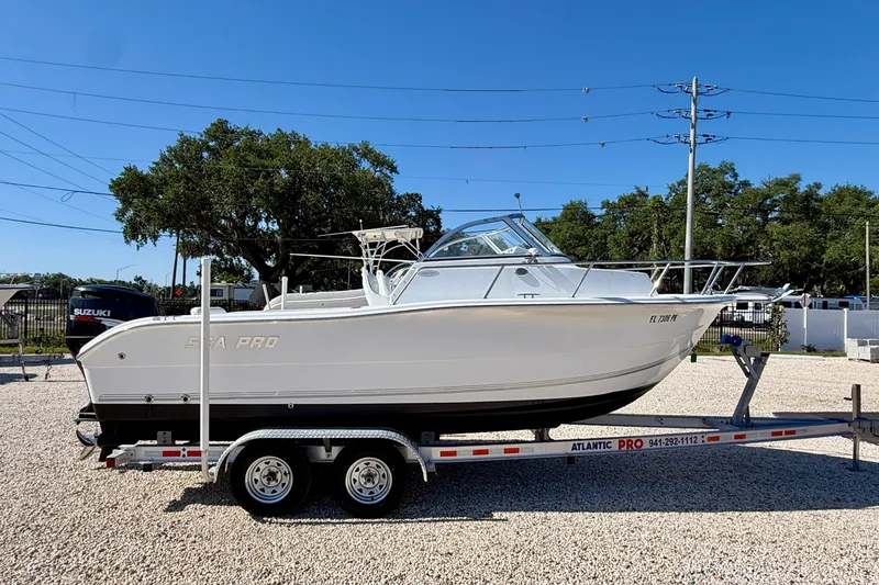 Slide: The Image of 2005 Sea Pro 220 Walk Around boat on trailer, parked outdoors under clear sky. - 4