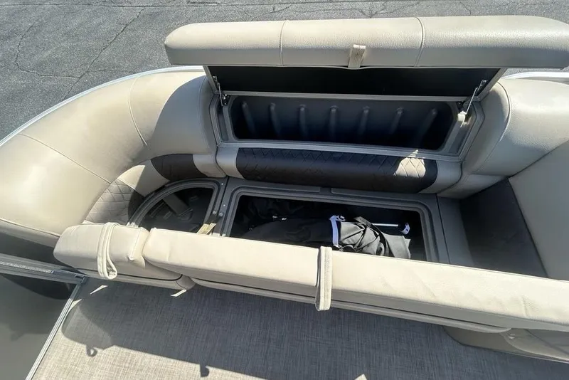 Slide: The Image of 2021 Sun Tracker Party Barge 20 DLX interior storage compartments open, showcasing seating and storage space. - 13