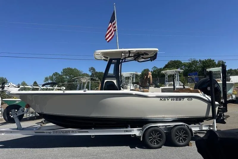 The Image of 2026 Key West 239 FSR boat on trailer with American flag, clear blue sky. - 1