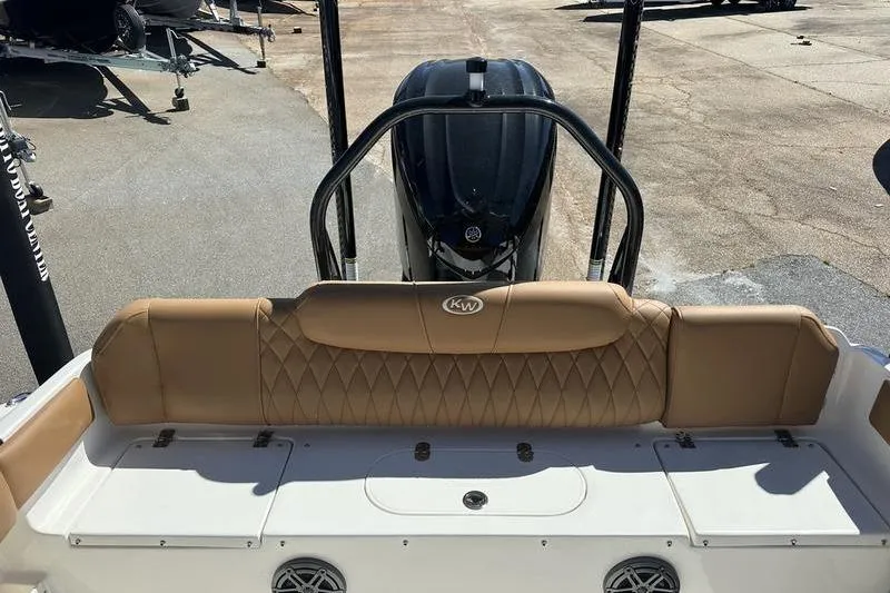 Slide: The Image of 2026 Key West 239 FSR boat interior with tan seating and visible outboard motor. - 16
