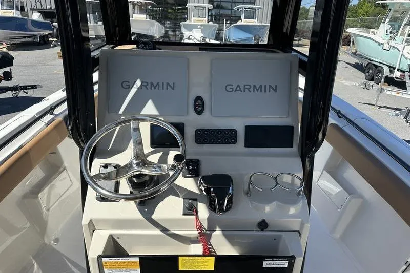Slide: The Image of 2026 Key West 239 FSR boat dashboard with Garmin navigation systems and steering wheel. - 4