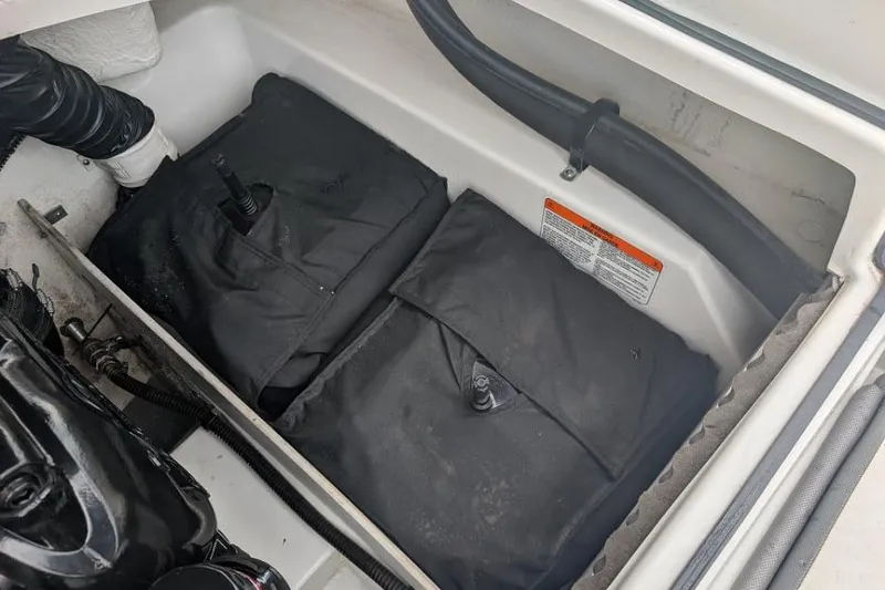 Slide: The Image of Storage compartment of a 2019 Tahoe 500 TF boat with black covers and hoses. - 15