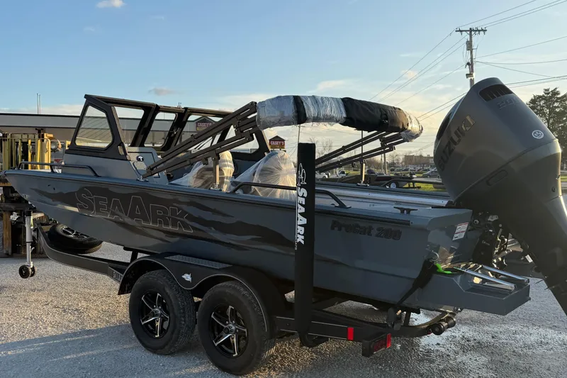 The Image of 2026 SeaArk ProCat 200 boat on trailer, featuring Suzuki outboard motor, parked outdoors. - 0