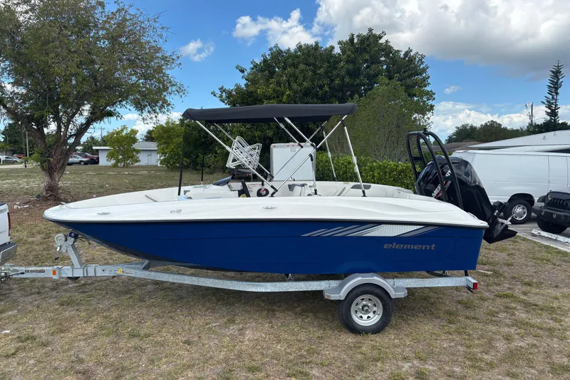 The Image of 2026 Bayliner Element E18 boat on trailer, parked outdoors under a cloudy sky. - 0