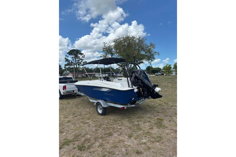 Slide: The Image of 2026 Bayliner Element E18 boat on trailer under blue sky. - 14