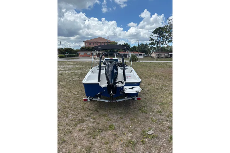 Slide: The Image of 2026 Bayliner Element E18 boat on trailer, parked on grassy area under cloudy sky. - 15