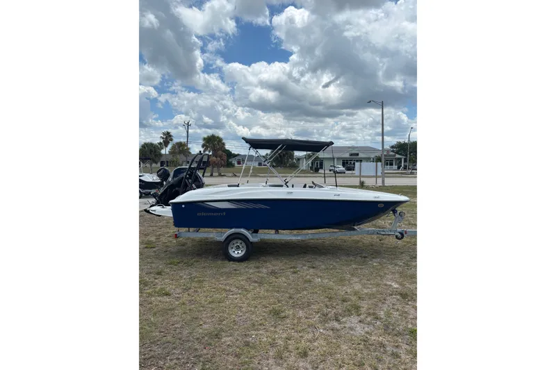 Slide: The Image of 2026 Bayliner Element E18 boat on trailer under cloudy sky. - 2