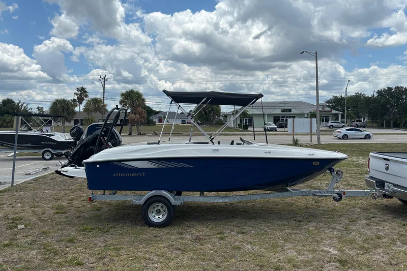 Slide: The Image of 2026 Bayliner Element E18 boat on trailer, parked outdoors under cloudy sky. - 3