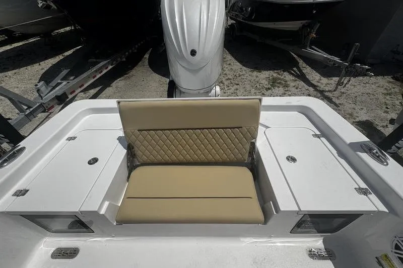 Slide: The Image of 2026 Sportsman Masters 247 Bay Boat with tan cushioned seating and outboard motor. - 10