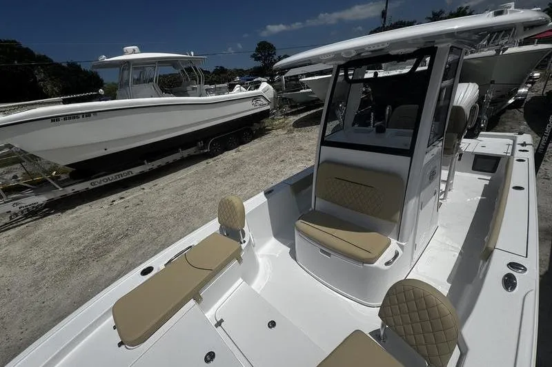Slide: The Image of 2026 Sportsman Masters 247 Bay Boat with tan seating, parked alongside another boat. - 13