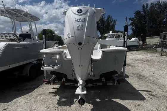 Slide: The Image of 2026 Sportsman Masters 247 Bay Boat with powerful outboard motor, parked outdoors. - 21