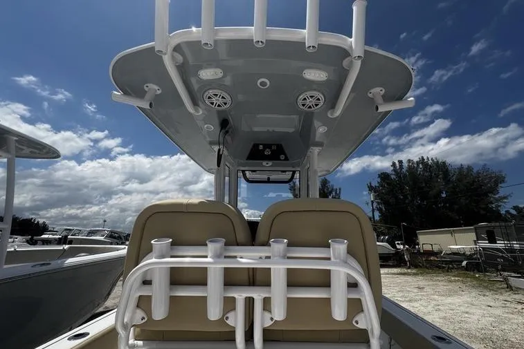 Slide: The Image of 2026 Sportsman Masters 247 Bay Boat with T-top and rod holders under a blue sky. - 4