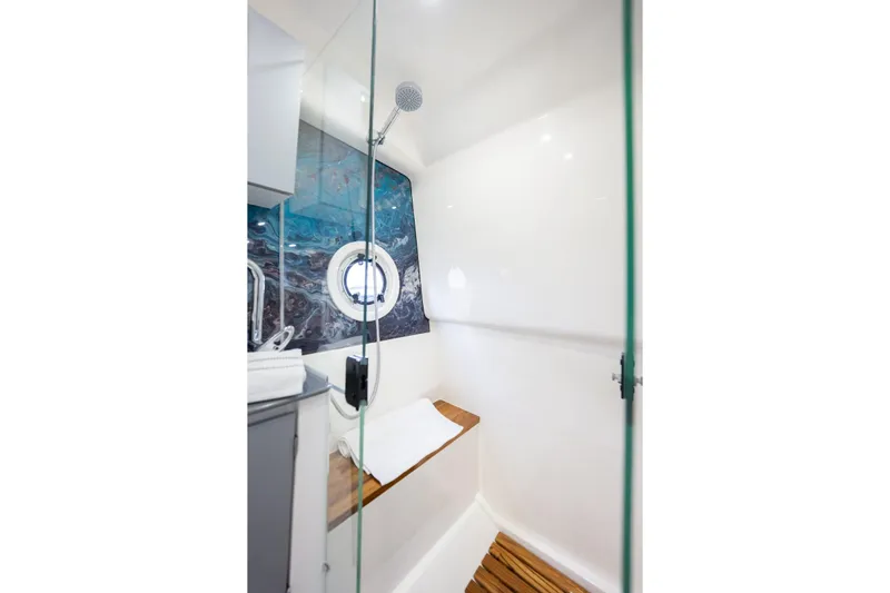 Slide: The Image of Modern shower cabin with glass door, wooden bench, and nautical-themed decor in Hanover 347, 2027 model. - 13