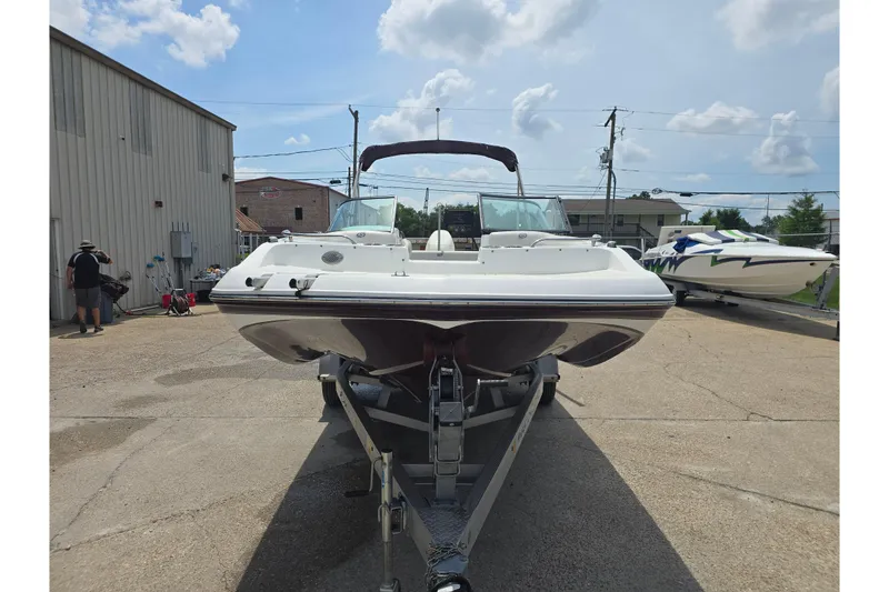 Slide: The Image of 2020 Hurricane SunDeck 187 OB boat on trailer, parked outdoors under a partly cloudy sky. - 2